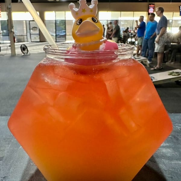 A large orange cocktail with a rubber duck wearing a crown, at One Eyed Jacks bar.