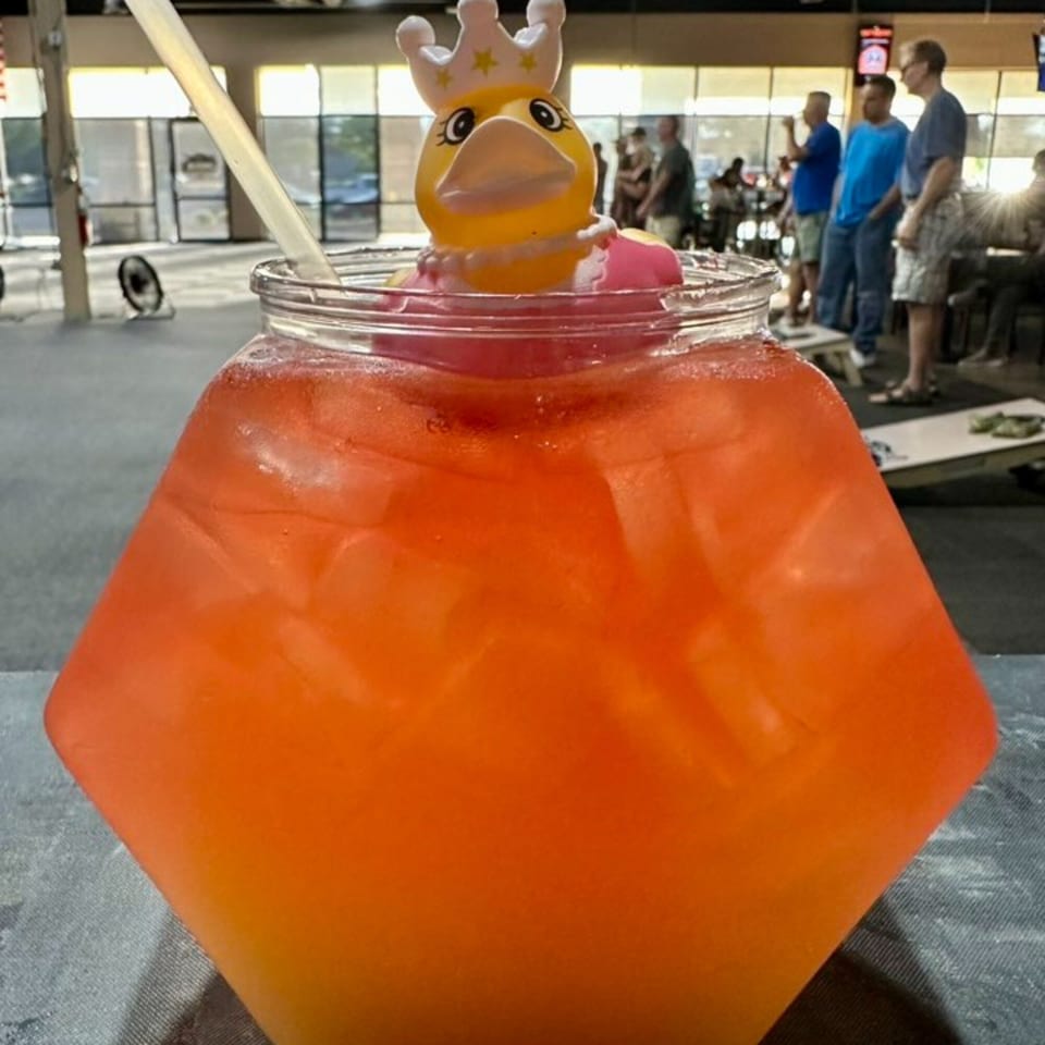 A large orange cocktail with a rubber duck wearing a crown, at One Eyed Jacks bar.