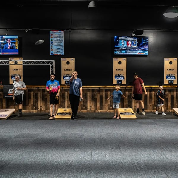 People of all ages playing cornhole at One Eyed Jacks, a bar-and-grill.