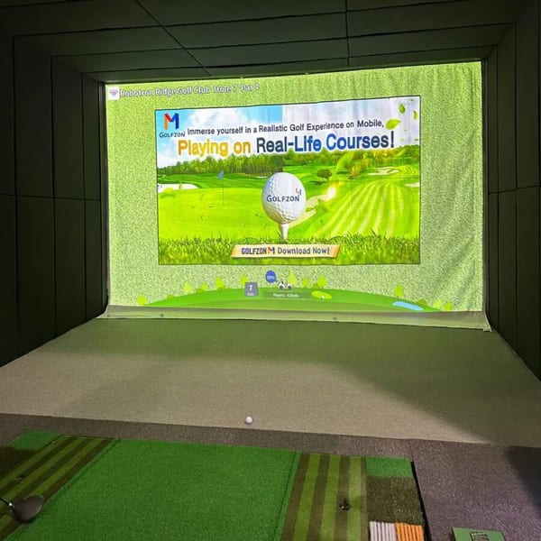 A golf simulator at One Eyed Jacks, showing a virtual golf course on a large screen.