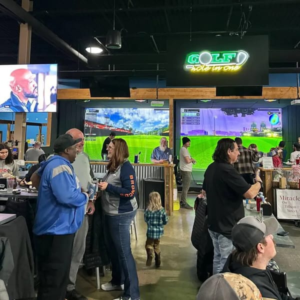 Patrons socialize and play golf simulators at One Eyed Jacks bar-and-grill.