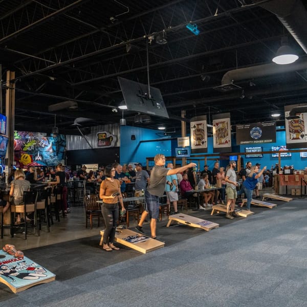 Patrons playing cornhole and socializing in the lively One Eyed Jacks bar-and-grill.